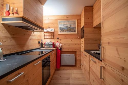 - une cuisine avec des murs en bois et des comptoirs en bois dans l'établissement Chalet Vorgeats 2 - 6 pers - Au pied de la Flégère - Golf - UTMB, à Chamonix-Mont-Blanc
