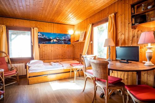 レ・ズッシュにあるDatcha of Sky -Jardin - Calme - 180 vues - 9 chambres & Studio Apptのデスク、ベッド、テレビが備わる客室です。