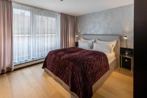 a hotel room with a bed and a large window at La Mansion Vi Vadi Hotel in Munich