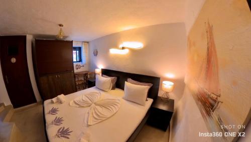 - une chambre avec un lit doté de draps et d'oreillers blancs dans l'établissement Sun Oniro Studio, à Samothráki