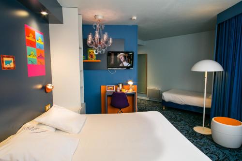 a bedroom with a white bed and a blue wall at Hotel Gabriel in Le Mont Saint Michel