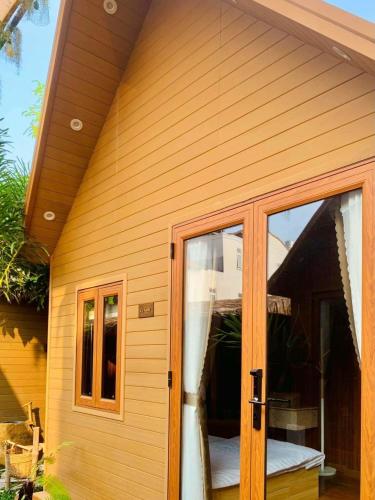 a sliding glass door on a house with a porch at Lá Garden Homestay in Long Xuyên