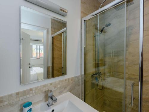 a bathroom with a shower and a sink and a mirror at 3 Bed in Camber 87987 in Camber