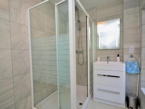W łazience znajduje się szklana kabina prysznicowa i umywalka. w obiekcie 3 Bed in Appledore 55363 w mieście Appledore