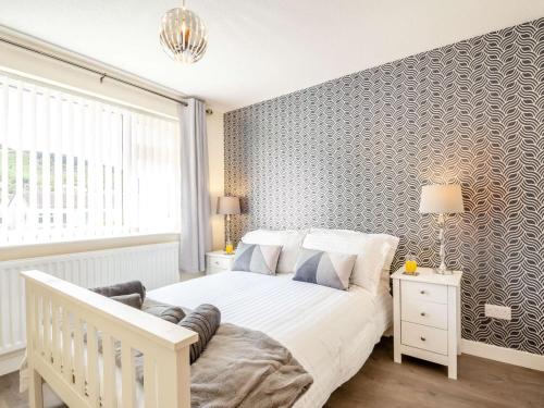 a bedroom with a white bed and a large window at 3 bed in Conwy 87866 in Penmaen-mawr