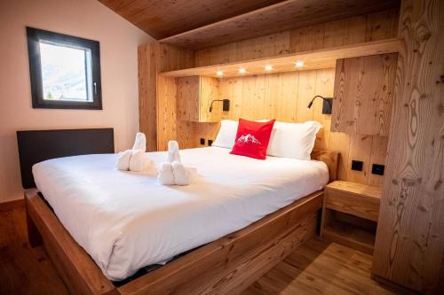 une chambre avec un grand lit blanc avec des oreillers rouges dans l'établissement Kinabalu - Vue Mt Blanc Range Les houches center, aux Houches