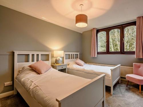 una camera con due letti e una sedia rosa di 5 bed in Burridge 89078 a Curdridge