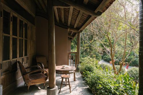a porch of a house with a table and chairs at TOKI Retreat Vân Long in Ninh Binh