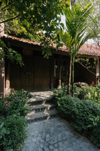 a house with a brick walkway leading to a building at TOKI Retreat Vân Long in Ninh Binh