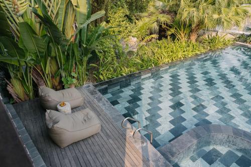 a swimming pool with two lounge chairs next to a resort at TOKI Retreat Vân Long in Ninh Binh