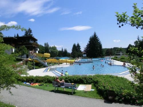 una gran piscina con gente. en Ferienhaus Nr 17, Typ B, Feriendorf Jägerpark, Bayerischer Wald, en Viechtach