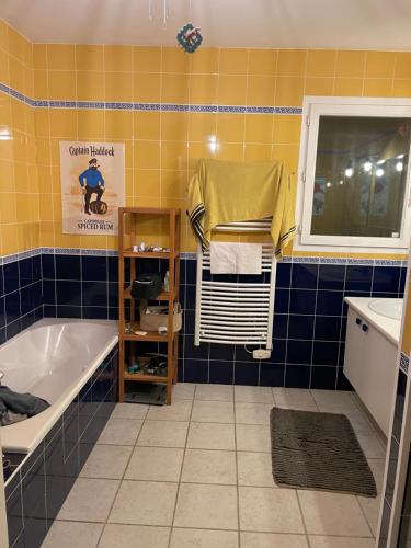 y baño con bañera y lavamanos. en Villa entre bordeaux et saint emilion, en Cursan