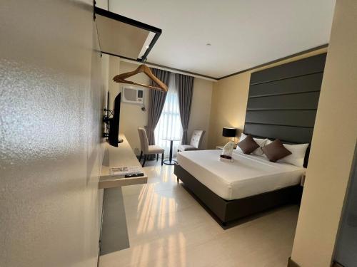 Habitación de hotel con cama y escritorio en Yes Hotel Imus Cavite, en Imus