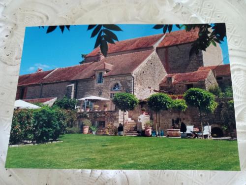 an old stone house with a green yard at Le Prieuré de l'Auxois in Alise-Sainte-Reine