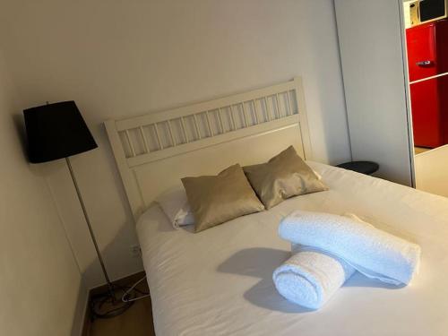 a bed with a towel on top of it at Studio très pratique ! in Le Mont-sur-Lausanne