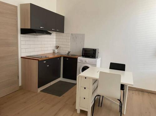 uma cozinha com uma mesa, uma mesa e um fogão em Studio très pratique ! em Le Mont-sur-Lausanne