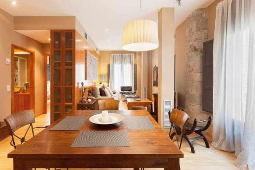 un salon avec une table et des chaises en bois dans l'établissement Sleep & Stay Apartamento de lujo, à Gérone