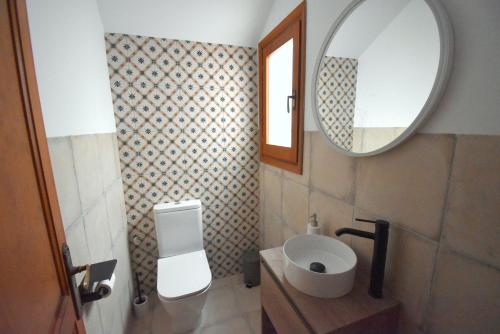 bagno con servizi igienici e specchio di Casa Rosa Javea a Jávea