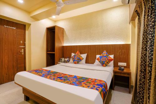 een slaapkamer met een groot bed in een kamer bij FabExpress Swagatham Residency in Mumbai