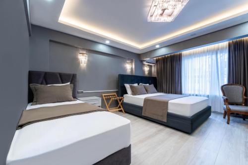 een slaapkamer met 2 bedden en een bank en een stoel bij Classio Hotel Kadıköy in Istanbul
