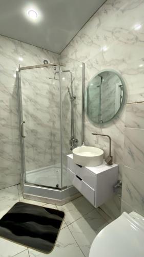 a white bathroom with a sink and a shower at Евродвушка в ЖК Каратал in Kostanay