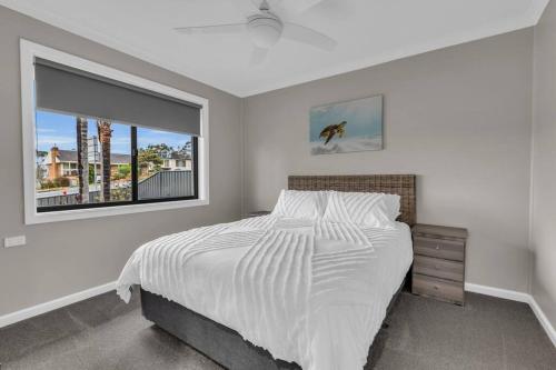 a white bedroom with a bed and a window at JackEllie Lodge - Pets welcome in Eden