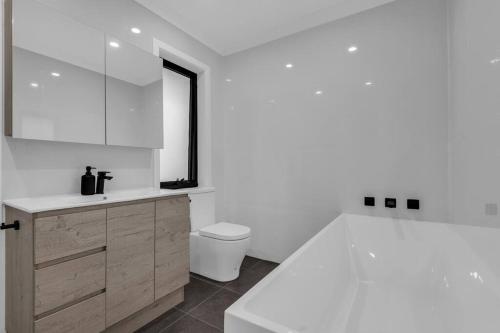 a white bathroom with a sink and a toilet at JackEllie Lodge - Pets welcome in Eden