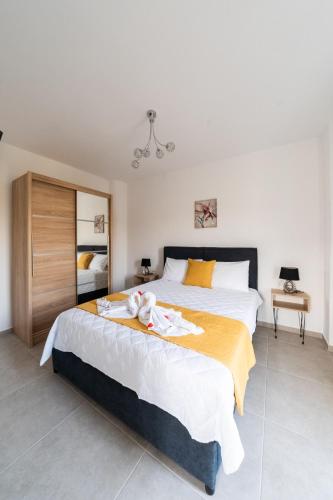 a bedroom with two beds and a chandelier at Villa Nontas Ntina with Private Pool & Playground in Rethymno Town