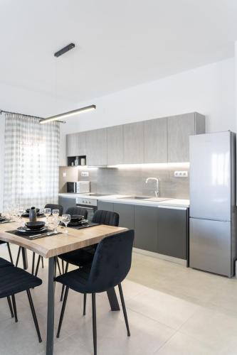 a kitchen with a table with chairs and a refrigerator at Villa Nontas Ntina with Private Pool & Playground in Rethymno Town