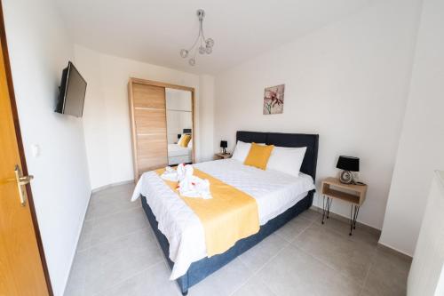 a bedroom with a large bed and a television at Villa Nontas Ntina with Private Pool & Playground in Rethymno Town