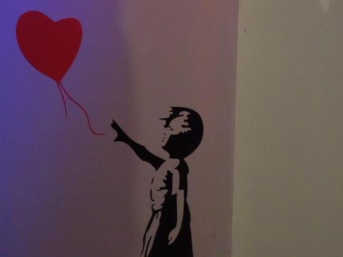 a stencil of a man holding a heart balloon at The Rendezvous Fullmoon Hostel in Haad Rin