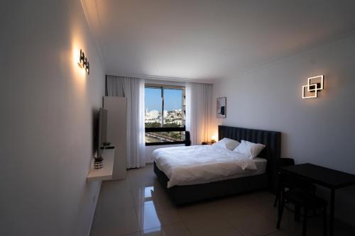a hotel room with a bed and a window at ocean apartments haifa in Haifa