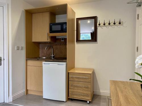 una pequeña cocina con nevera blanca y microondas en Sapphire Suites, en Reading