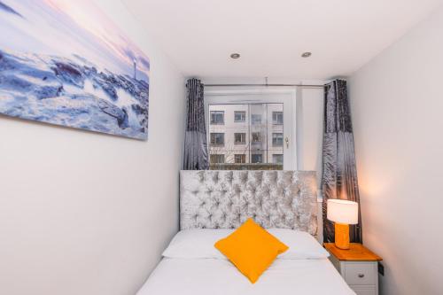 Schlafzimmer mit einem Bett und einem Fenster in der Unterkunft Superb Luxury Quality Central Apartment on Canal in Edinburgh