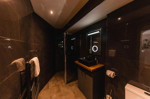 Baño negro con lavabo y ducha en Superb Luxury Quality Central Apartment on Canal, en Edimburgo