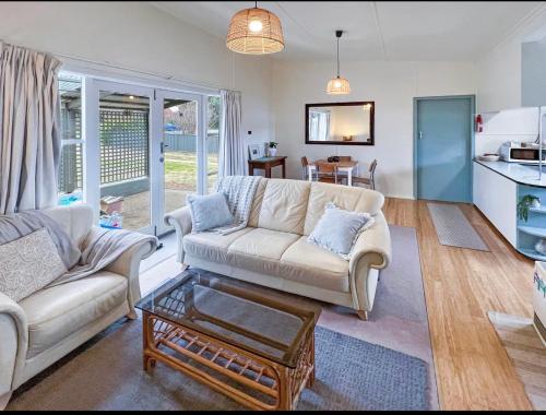 a living room with a couch and a table at Cute Cosy 2BR House - Best Value in Berridale