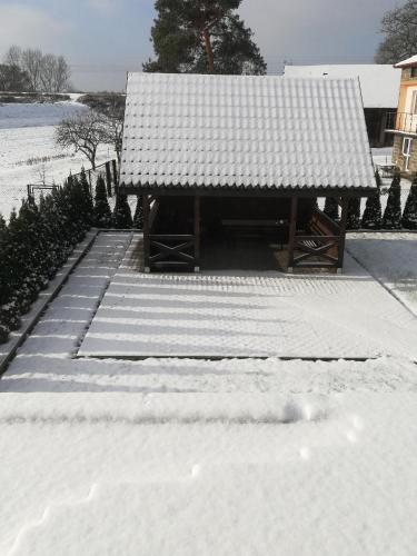 a snow covered building with a roof on top of it at Przystań Przylasek in Krakow