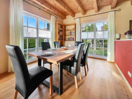 uma sala de jantar com uma mesa de madeira e cadeiras pretas em Weber-Grill # Kamin # Indoorschaukel # Bose-Anlage em Wernigerode