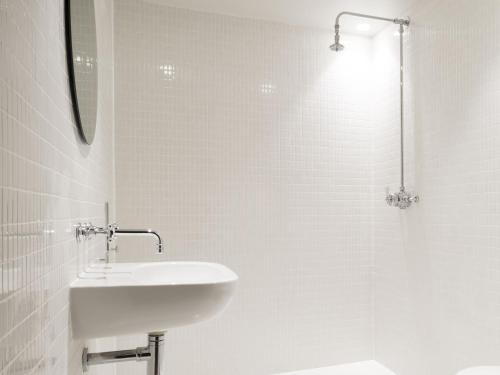 een witte badkamer met een wastafel en een douche bij Channel View, Dungeness by Bloom Stays in Dungeness