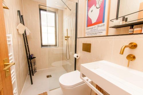 a bathroom with a toilet and a sink and a shower at Coastal Gem With Hot Tub in Kent