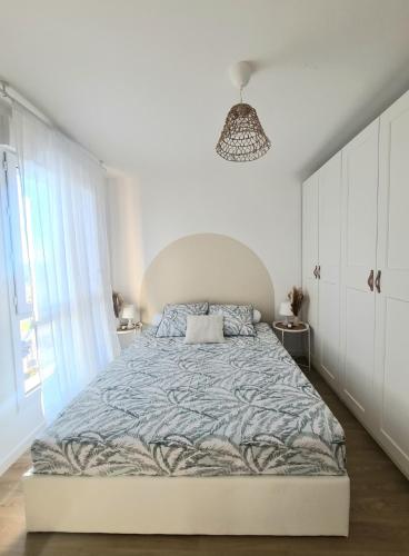 een witte slaapkamer met een groot bed en een raam bij Moderne et charmant T2 in Villiers-le-Bel
