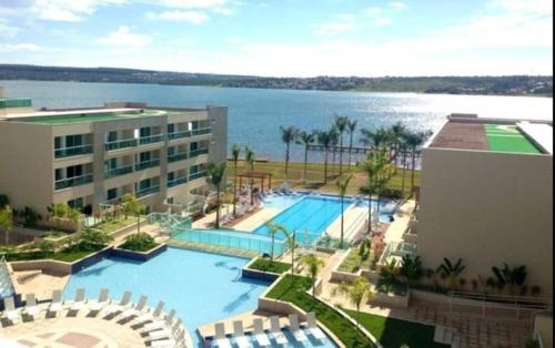una gran piscina junto a un edificio y el agua en Luxuoso Flat Brisas do Lago Terraço Aconchegante, en Brasilia