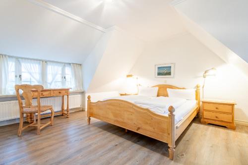 Schlafzimmer mit einem Bett, einem Schreibtisch und einem Stuhl in der Unterkunft Friesenhaus Kaeptn Hahn Hausteil 05 in Westerland