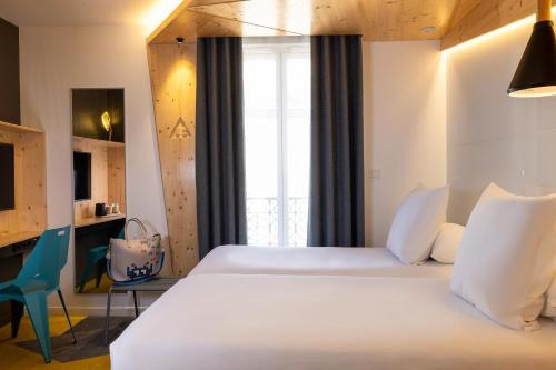 - une chambre avec un grand lit blanc et un bureau dans l'établissement Urban Bivouac Hotel, à Paris