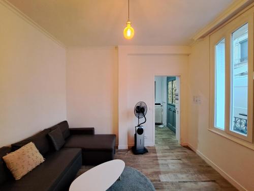 a living room with a couch and a window at DAVID - maison de ville, 3 chambres in Reims