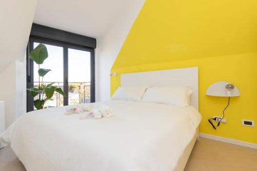 una camera con un letto bianco e una parete gialla di Kill Bill's Retreat - 10 minuti dal Duomo a Milano