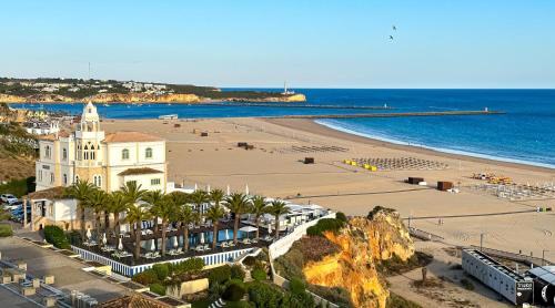 a view of a beach with a building and the ocean at Hostel da Praia in Portimão