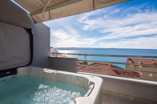 a bath tub on a balcony with a view of the ocean at Prestige Apartments in Jesenice