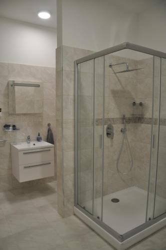 a bathroom with a shower and a sink at Üveghuta Vendégház in Vágáshuta