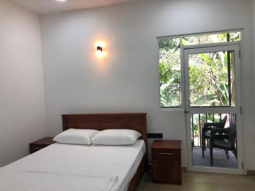 um quarto com uma cama e uma janela com uma cadeira em SERENE HOME em Kandy